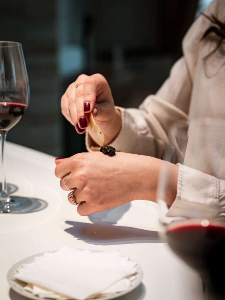 Accord mets et vins lors d’un atelier œnologique à Bordeaux, avec dégustation de caviar accompagnée d’un verre de vin rouge.