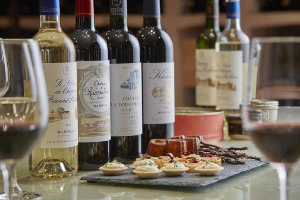 Dégustation de vins de Bordeaux accompagnée de mets raffinés, illustrant une expérience œnologique et gastronomique à offrir