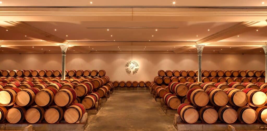 Chai de vieillissement du vignoble bordelais, avec rangées de barriques en chêne utilisées pour l’élevage des grands vins de Bordeaux.